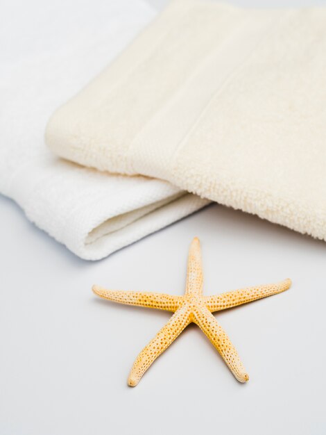 Towels and starfish on white background