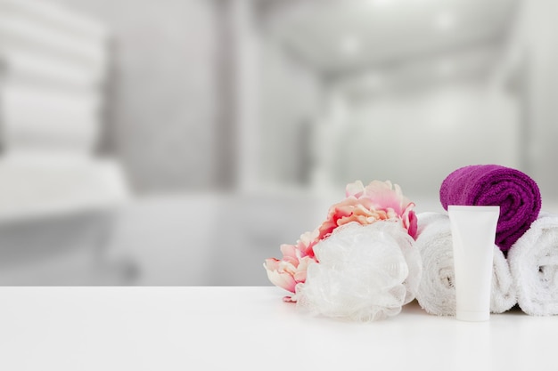 Towels with flowers on light table against blurred background