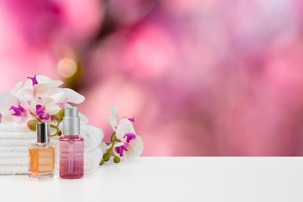 Towels with flowers on light table against blurred background