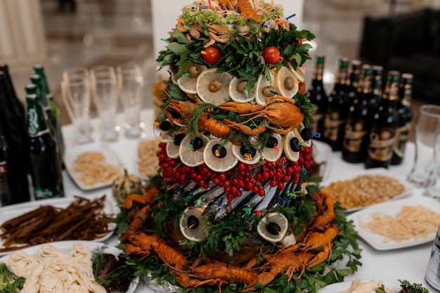 Башня из морепродуктов, креветок, зелени и раков на вкусном столе буфета