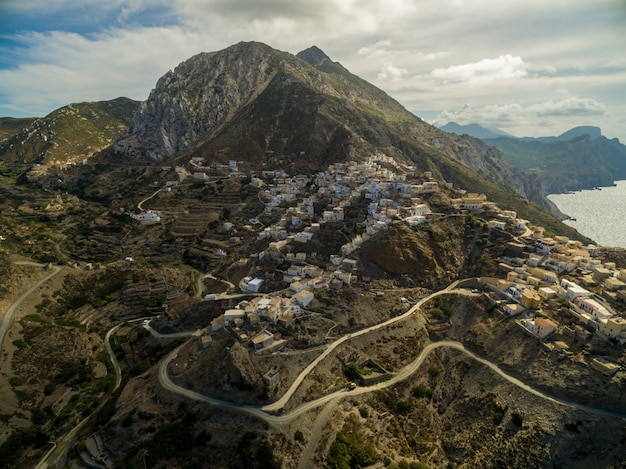 Town in Greece with rocky mountains and roads surrounded by sea