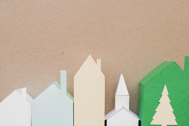 Бесплатное фото Город сделан из разного типа бумаги на коричневом фоне