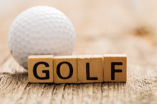 Игрушечные кирпичи на столе со словом GOLF и мячом для гольфа