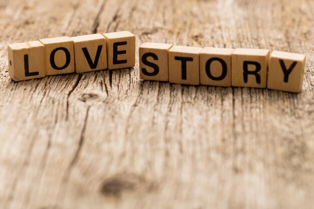 Игрушечные кирпичи на столе со словом Love Story