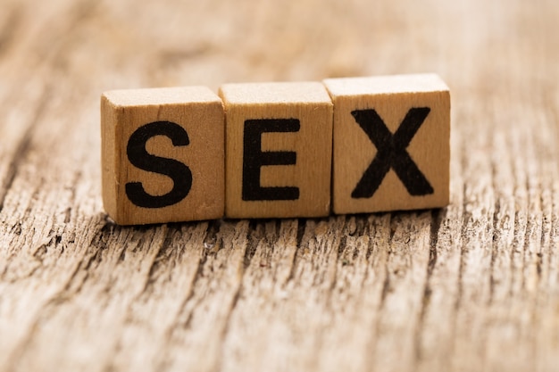 単語のセックスとテーブルの上のおもちゃのレンガ