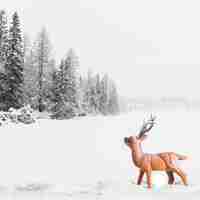 Free photo toy deer between field with trees in snow