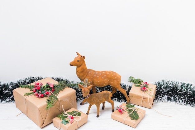 Toy deer near present boxes and tinsel