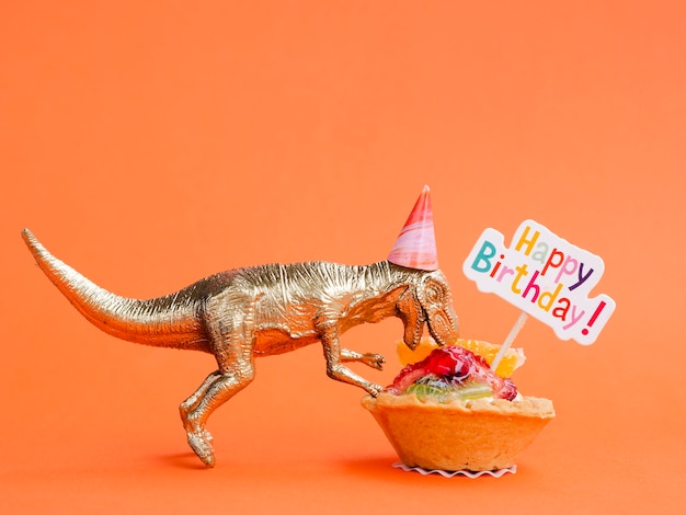誕生日のお菓子を食べるおもちゃの恐竜