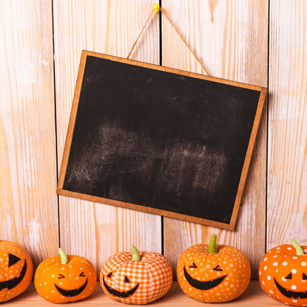 Toy jack-o-lanterns near chalkboard