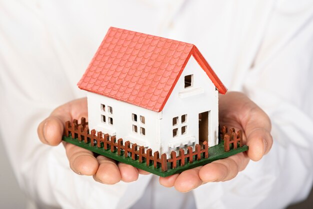 Toy model house held in hands close-up