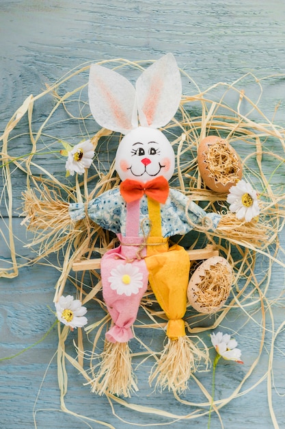 Toy rabbit on hay and flowers