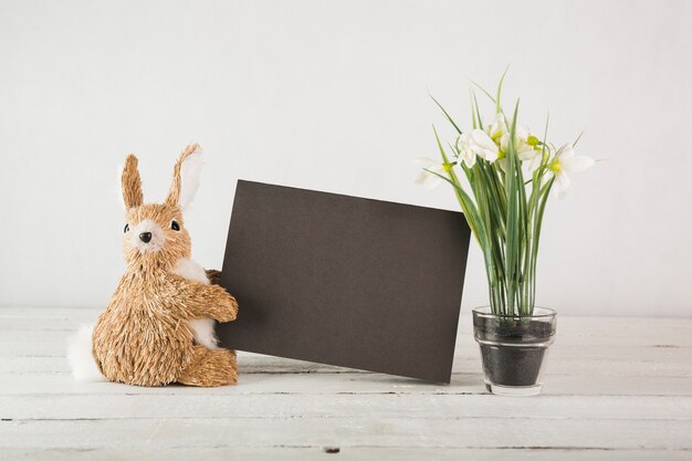 Toy rabbit near snowdrops