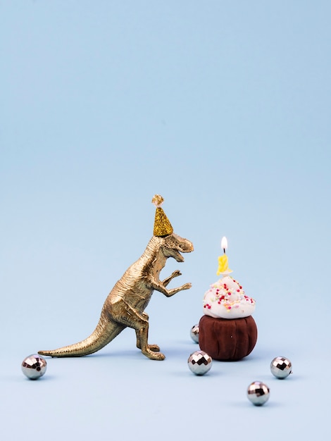 Toy t-rex and little birthday dessert