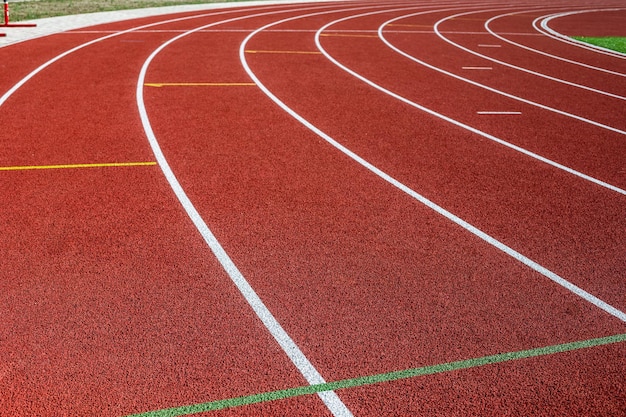 Бесплатное фото Бег по треку. красная беговая дорожка в спортивной сфере. спортивный стадион под открытым небом