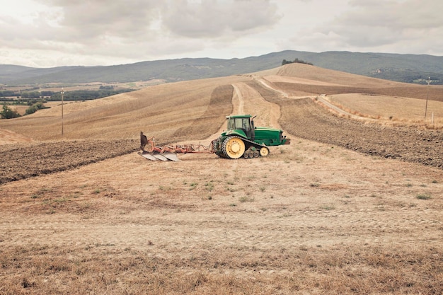 трактор в сельской местности, тоскана, италия