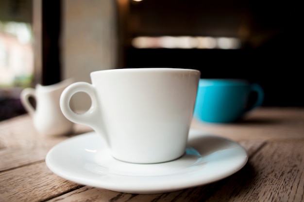 伝統的な白いコーヒーカップ、木製のテーブル