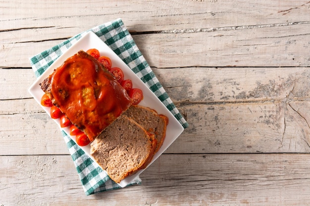 Traditional American meatloaf with ketchup on rustic wooden table