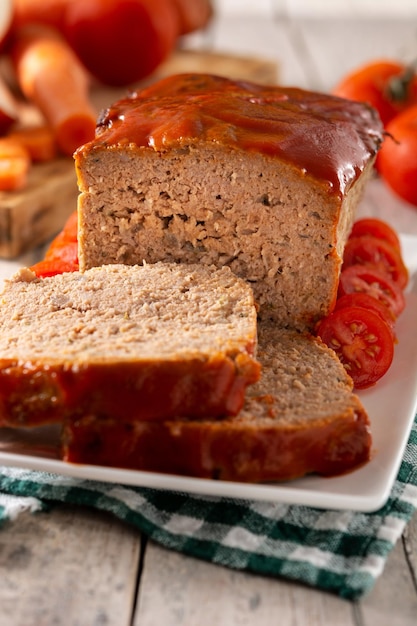 Traditional American meatloaf with ketchup on rustic wooden table