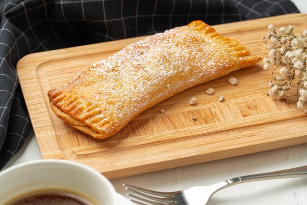Traditional apple strudel on wooden board close up