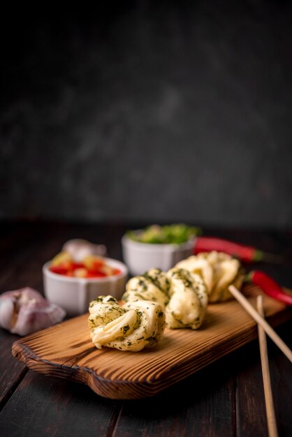 Traditional asian food on wooden board with garlic and chopsticks