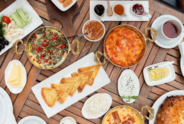 Traditional azerbaijani breakfast with egg dish, pancakes, fresh salad, jam, cheese, honey