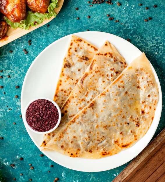 Traditional azerbaijani meat gutab minced meat stuffed flatbread served with sumac