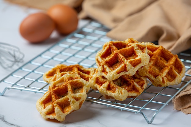 Traditional Belgian waffles, blood oranges and blueberries dressing and cup of coffee for sweet breakfast, composition on light background.