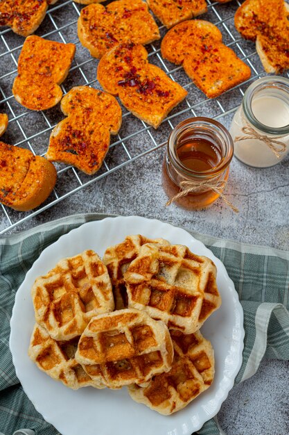 Traditional Belgian waffles, blood oranges and blueberries dressing and cup of coffee for sweet breakfast, composition on light background.