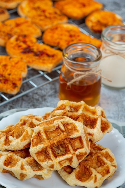 Free photo traditional belgian waffles, blood oranges and blueberries dressing and cup of coffee for sweet breakfast, composition on light background.