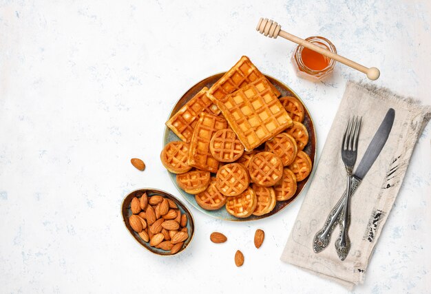 Traditional belgian waffles with fresh berries and honey on grey concrete surface. 