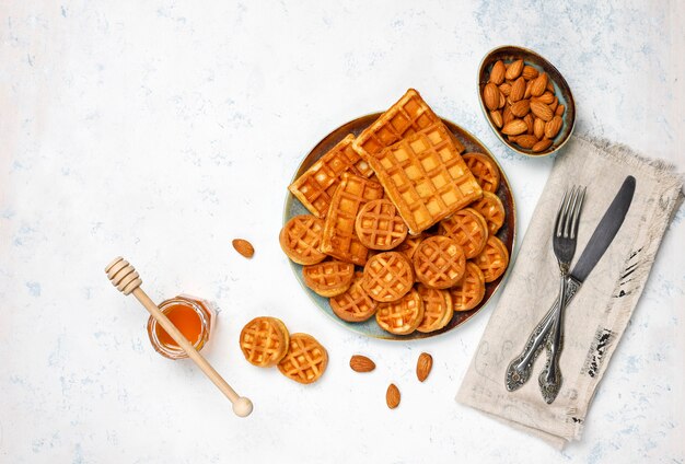 Traditional belgian waffles with fresh berries and honey on grey concrete surface. 