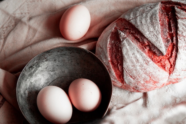 Free photo traditional bread, egg bowl on a white rustic towel.