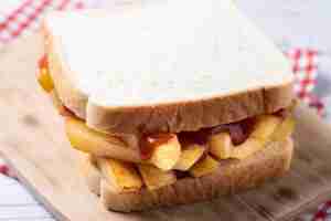 Free photo traditional british chip butty french fry sandwich on wooden table