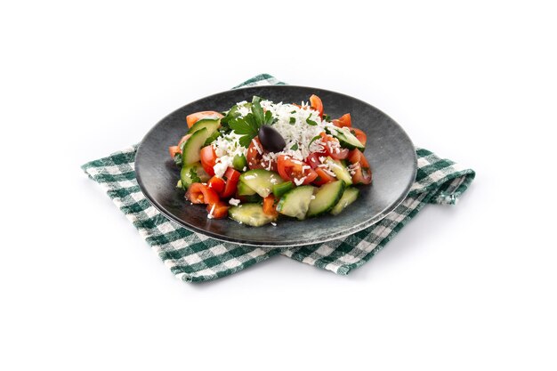 Traditional Bulgarian shopska salad with tomatocucumber and bulgarian sirene cheese on wooden table