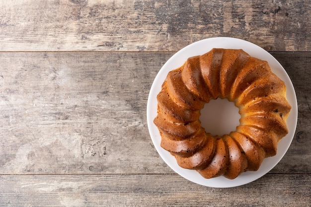 Traditional bundt cake piece with raisins on wooden table