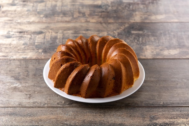 Traditional bundt cake piece with raisins on wooden table