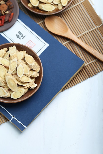 Traditional Chinese medicine and ancient medical book on white desk