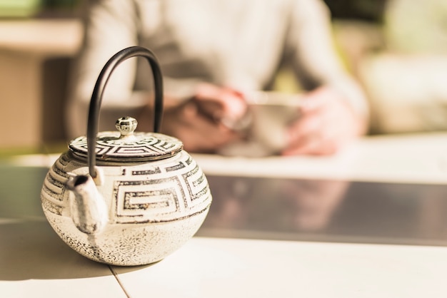 Традиционный китайский чайник с крышкой на столе в солнечном свете