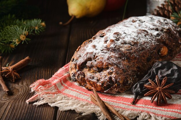 Traditional Christmas Swiss Pear Bread - Birnbrot or Birnweggen (Panelle pere) is local dish filled with dried pear fruits and nuts. Selective focus. Pie close-up on wooden table. New Year's tea party