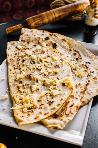 Traditional dish meat kutab with grated cheese on the top side view