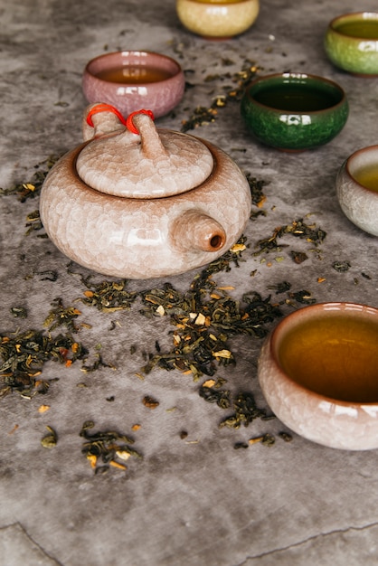 Teiera e tazze da tè orientali tradizionali su fondo concreto