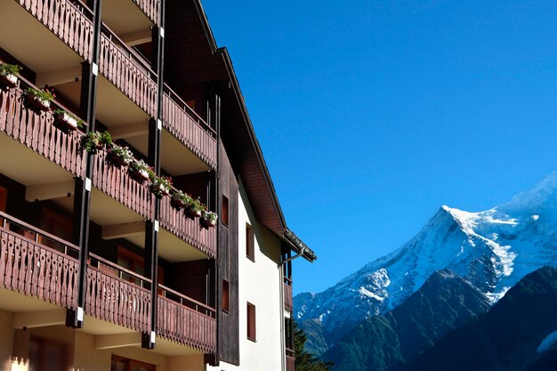 伝統的なヨーロッパのアルペンスキーシャレーホテル、遠くにアルプスの景色。青い空にスペースをコピーします。