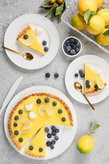 Free photo traditional french lemon pie with blueberries on a white stone background