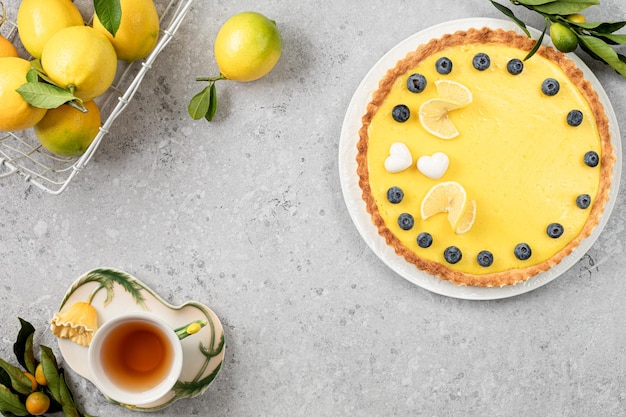 Foto gratuita tradizionale torta di limoni francese con mirtilli su uno sfondo di pietra bianca