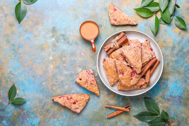 Free photo traditional homemade english scones with frozen raspberries and cinnamon,top view