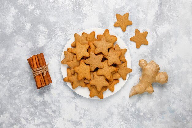 灰色のコンクリートの伝統的な自家製ジンジャーブレッドクッキー、クローズアップ、クリスマス、トップビュー、フラットレイアウト