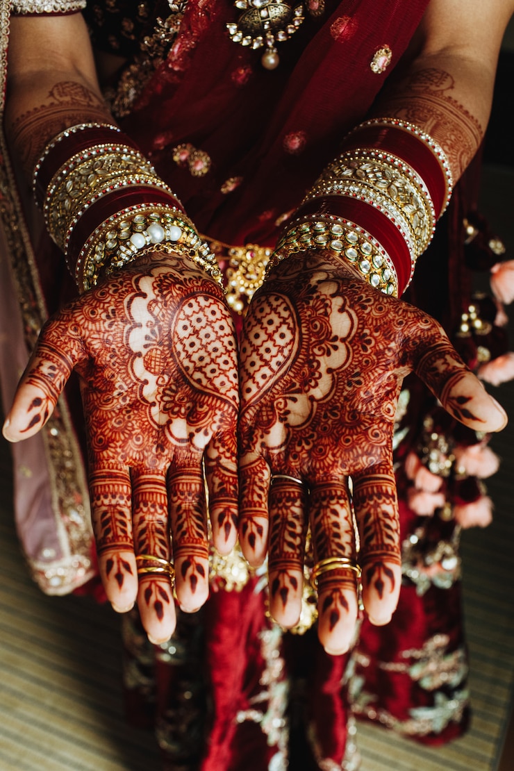 Free Photo traditional indian heart ornament on hands colored by henna and bridal bracelets in bordeaux colours