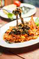 Бесплатное фото Традиционное итальянское блюдо черная тальятелле с морепродуктами