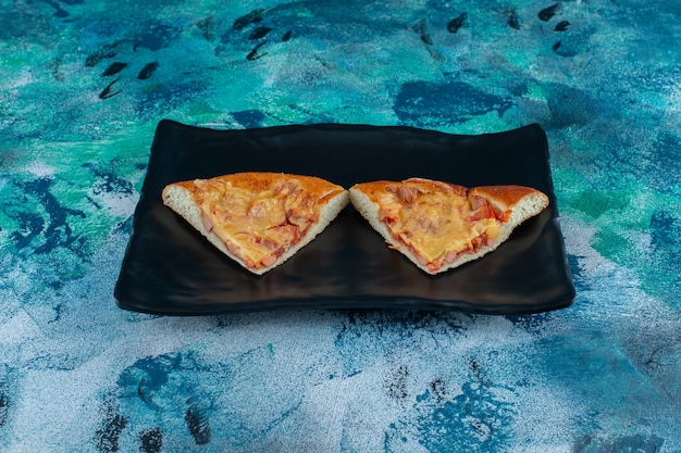 Traditional Italian mini pizza on a the wooden plate , on the marble table. 