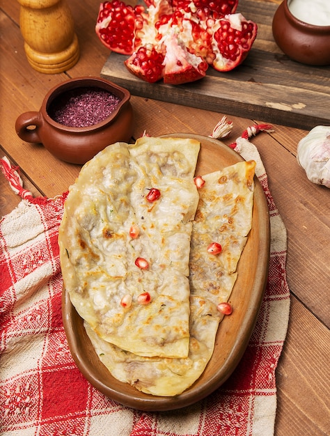 Sumakh와 석류 씨앗 나무 보드에 전통적인 고기 야채 구이 탭, qutab, gozleme